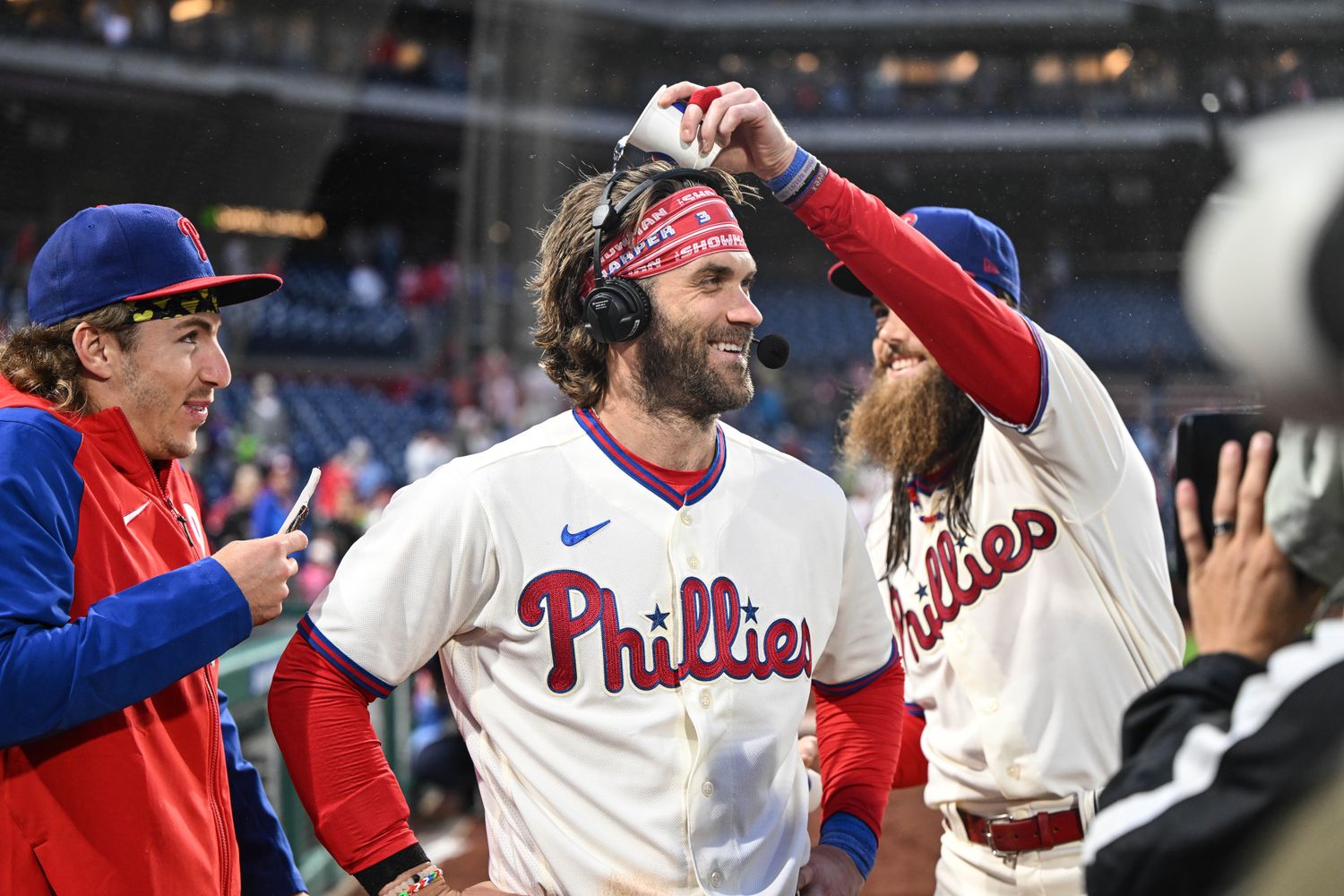 Sep 23, 2023; Philadelphia, Pennsylvania, USA; Philadelphia Phillies center fielder Brandon Marsh and second baseman Bryson Stott harass designated hitter Bryce Harper during a post game interview after the game against the New York Mets at Citizens Bank Park. Philadelphia won 7-5. Mandatory Credit: John Geliebter-USA TODAY Sports